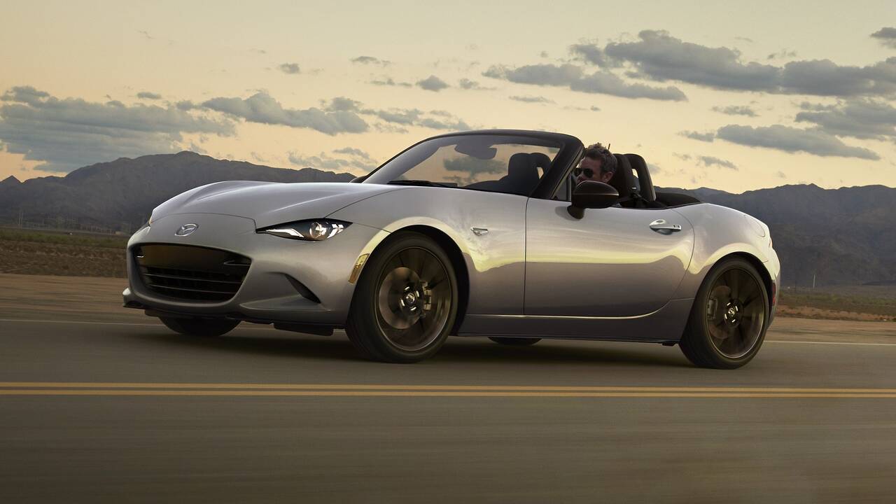 2024 Mazda MX-5 Miata driving with the top down, front side view